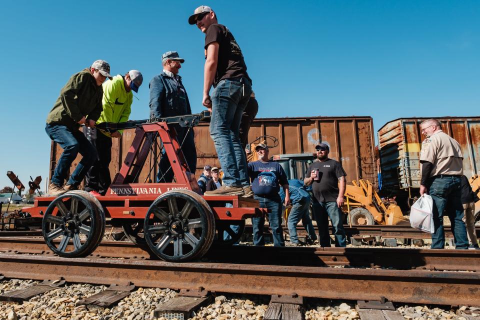 Scouts from area local troops try their hand at operating a vintage handcar during the railroad merit badge program at the Age of Steam Roundhouse Museum in Sugarcreek.