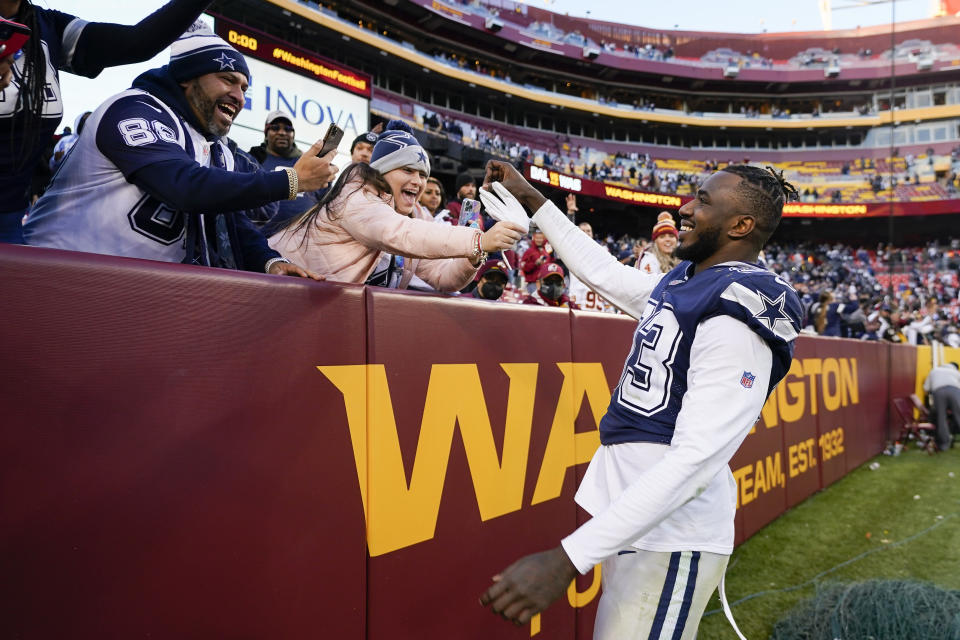 Dallas Cowboys defensive end Tarell Basham (93) giving away his gloves to a fan at the end of an NFL football game against the Washington Football Team, Sunday, Dec. 12, 2021, in Landover, Md. Dallas won 27-20. (AP Photo/Julio Cortez)