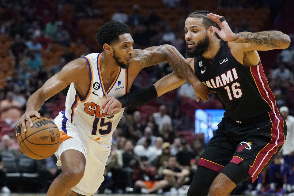 Phoenix Suns guard Cameron Payne (15) dribbles the ball as Miami Heat forward Caleb Martin (16) defends during the first half of an NBA basketball game Monday, Nov. 14, 2022, in Miami. (AP Photo/Marta Lavandier)