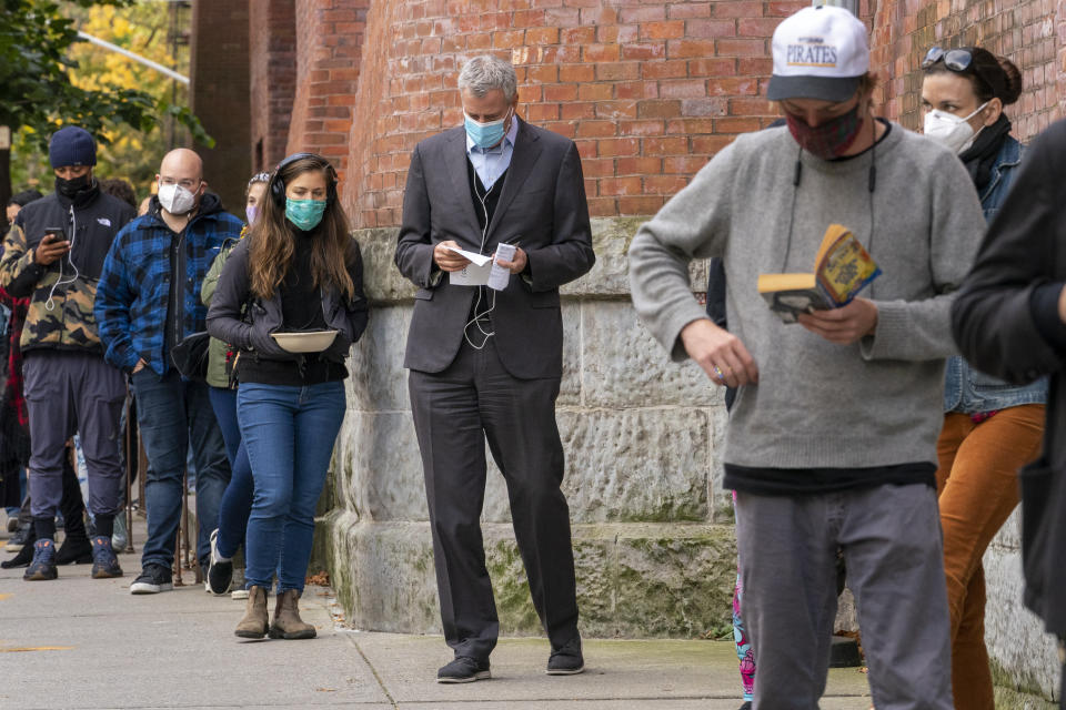 New York Mayor Bill de Blasio, center, stands in line to cast his early vote at the Park Slope Armory YMCA, Tuesday, Oct. 27, 2020, in the Brooklyn borough of New York. The mayor waited over three hours in line to cast his vote. (AP Photo/Mary Altaffer)