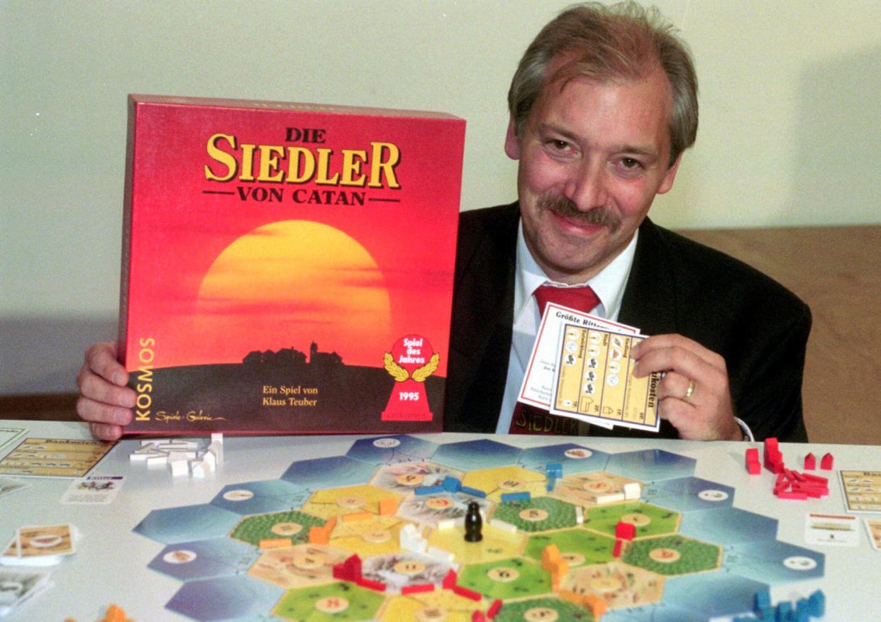 Klaus Teuber, a dental technician from Darmstadt, presents his game "The Settlers of Catan", Friday, Sept. 29, 1995, in Frankfurt, Germany. Teuber, creator of the hugely popular Catan board game in which players compete to build settlements on a fictional island, passed away on April 1, 2023 after a short and serious illness, according to a family statement. He was 70.