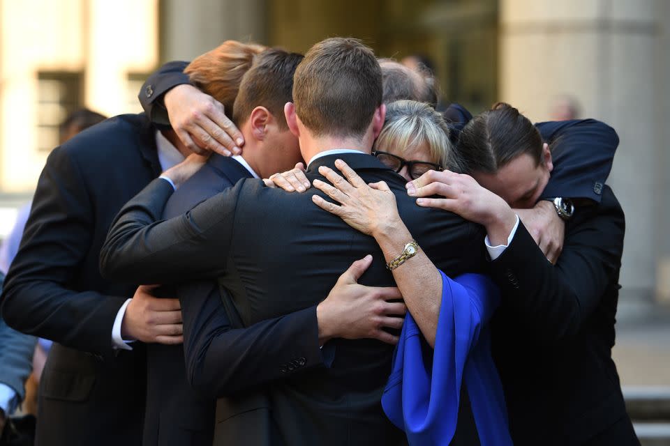 Family and friends of Rebecca Wilson embraced after carrying her casket to the hearse. Photo: AAP