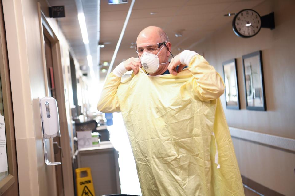 Dr. Paul Branca suits up in protective gear to go into a COVID-positive patient’s room at the University of Tennessee Medical Center.