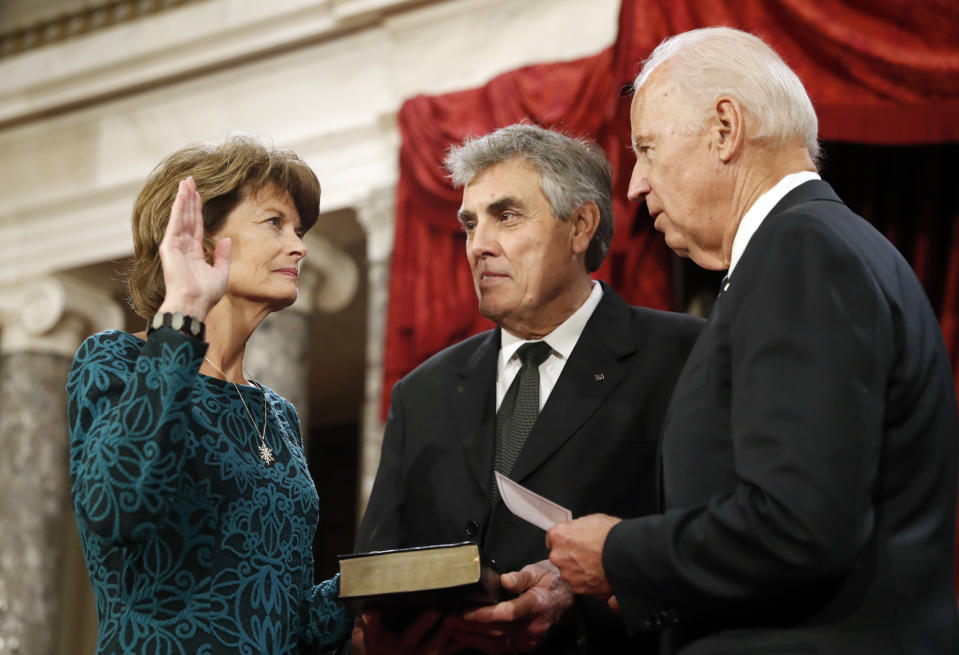 FILE - In this Jan. 3, 2017, file photo, Vice President Joe Biden, right, after administers the Senate oath of office to Sen. Lisa Murkowski, R-Alaska, as her husband Verne Martell holds a Bible, during a mock swearing in ceremony in the Old Senate Chamber on Capitol Hill in Washington as the 115th Congress begins. The oath, which normally doesn’t attract much attention, has become a common subject in the final days of the Trump presidency, being invoked by members of both parties as they met Wednesday, Jan. 6, 2021 to affirm Biden's win and a pro-Trump mob stormed the U.S. Capitol. Murkowski vowed to honor the oath she took and affirm the results of the presidential election while urging colleagues to do the same. (AP Photo/Alex Brandon, File)