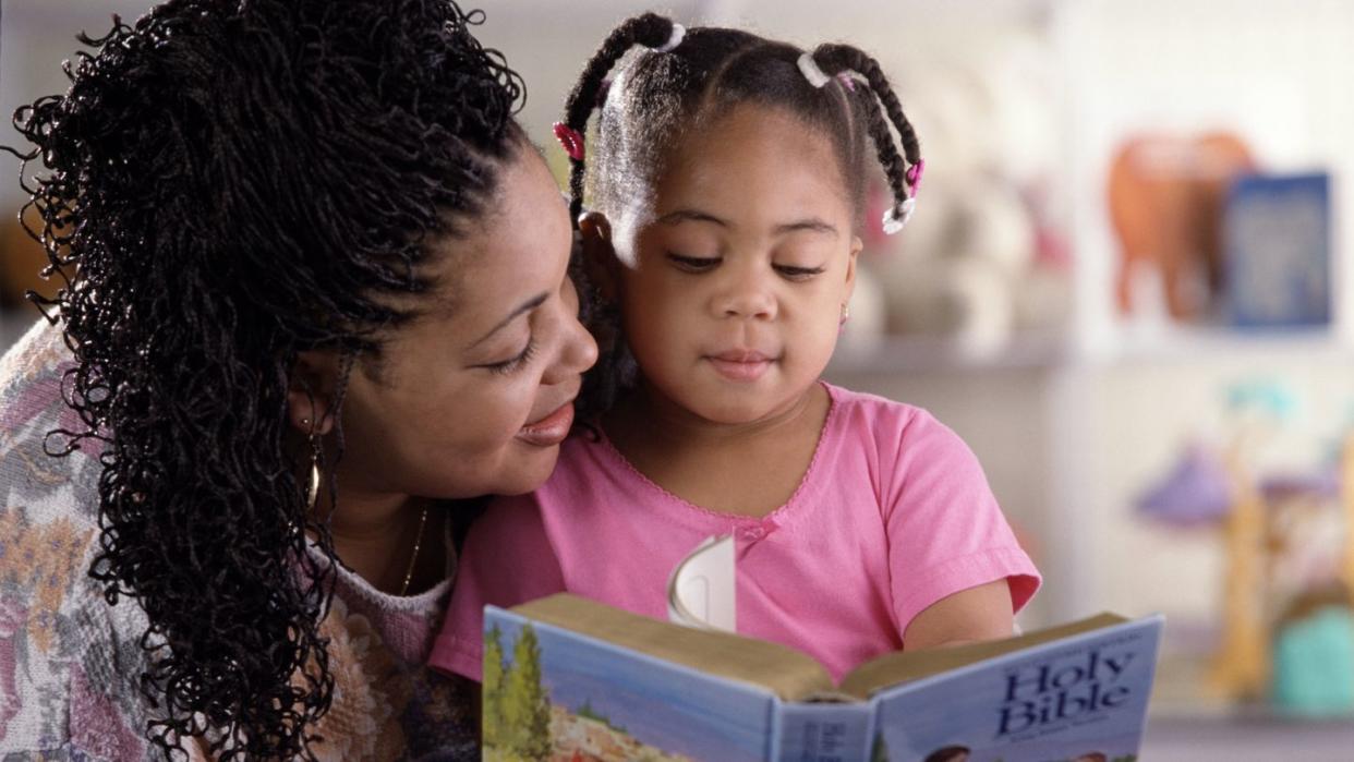 a mom reading to her little girl the bible