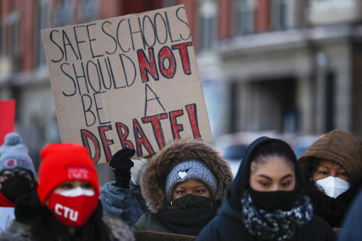 Members of the Chicago Teachers Union listen to speakers at a press conference outside of John Spry Community School