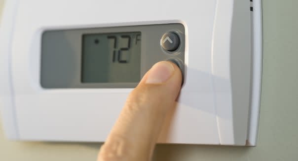 Man adjusting thermostat