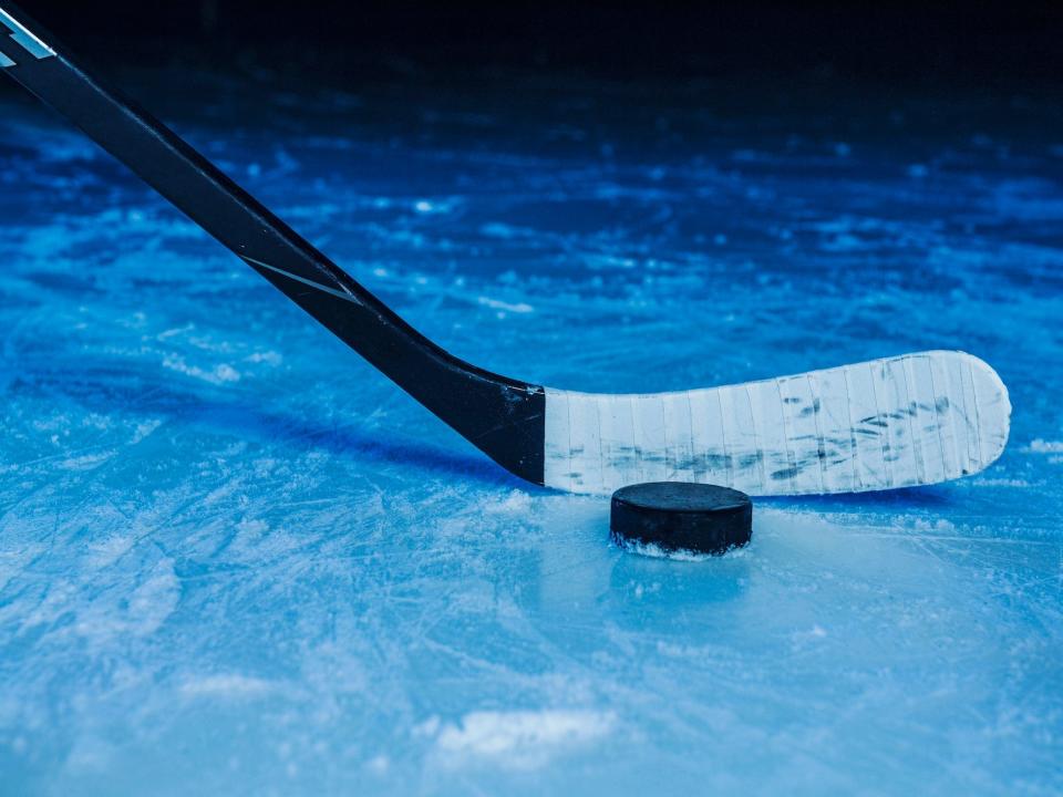 A hockey stick and puck on ice.