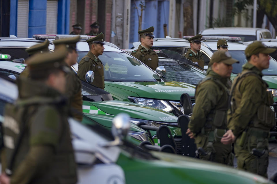 Policías chilenos junto a sus patrullas durante una ceremonia de inicio del programa "Calles sin Violencia" patrocinado por el gobierno en Santiago de Chile, el lunes 24 de abril de 2023. (AP Foto/Esteban Felix)