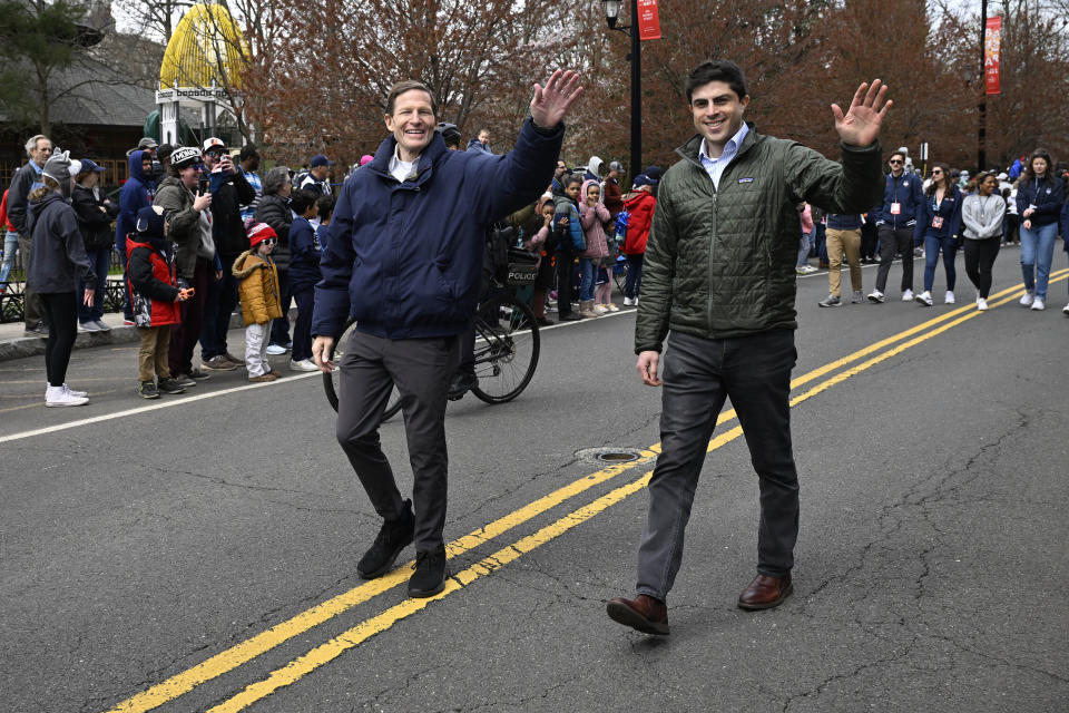 U.S> Sen. Richard Blumenthal, D-Conn., left, walks with his son state Rep. Matt Blumenthal D-Stamford during a parade to celebrate UConn's NCAA college basketball championship, Saturday, April 13, 2024, in Hartford, Conn. (AP Photo/Jessica Hill)