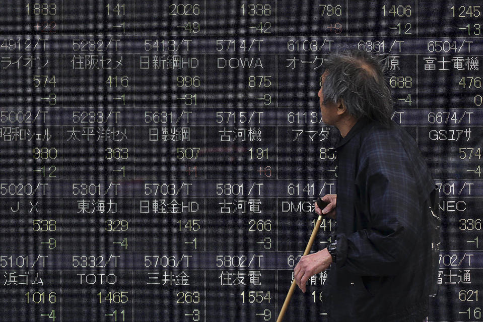 A man looks at a stock price chart on a street in Tokyo, Monday, March 10, 2014. Asian stock markets sank Monday, battered by weak Chinese trade and a reduced estimate for Japan's economic growth. Shares in Malaysia Airlines tumbled on news of the weekend disappearance of one its jets enroute to Beijing. Japan's Nikkei 225 fell 1.1 percent to 15,111.92. (AP Photo/Eugene Hoshiko)