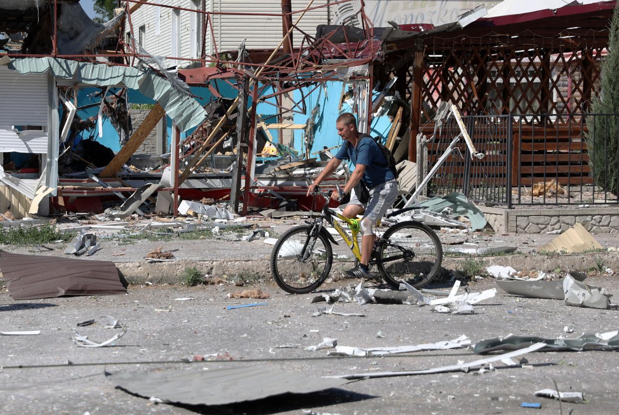 A man rides a bicycle among debris in Lysychansk on June 21, 2022, as Ukraine says Russian shelling has caused "catastrophic destruction" in the eastern industrial city, which lies just across a river from Severodonetsk where Russian and Ukrainian troops have been locked in battle for weeks. 