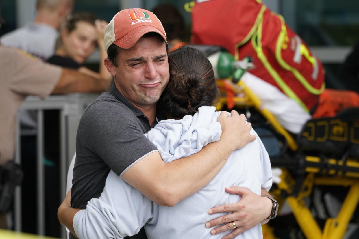 A couple embrace as they wait for news of survivors from a condominium that collapsed, Thursday, June 24, 2021 in Surfside, Fla. Dozens of survivors were pulled out, and rescuers continue to look for more.