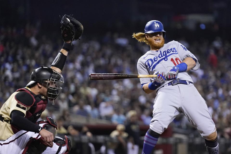 Los Angeles Dodgers' Justin Turner, right, backs away from an inside pitch as Arizona Diamondbacks catcher Carson Kelly reaches up to make the catch during the eighth inning of a baseball game Friday, June 18, 2021, in Phoenix. The Dodgers won 3-0. (AP Photo/Ross D. Franklin)