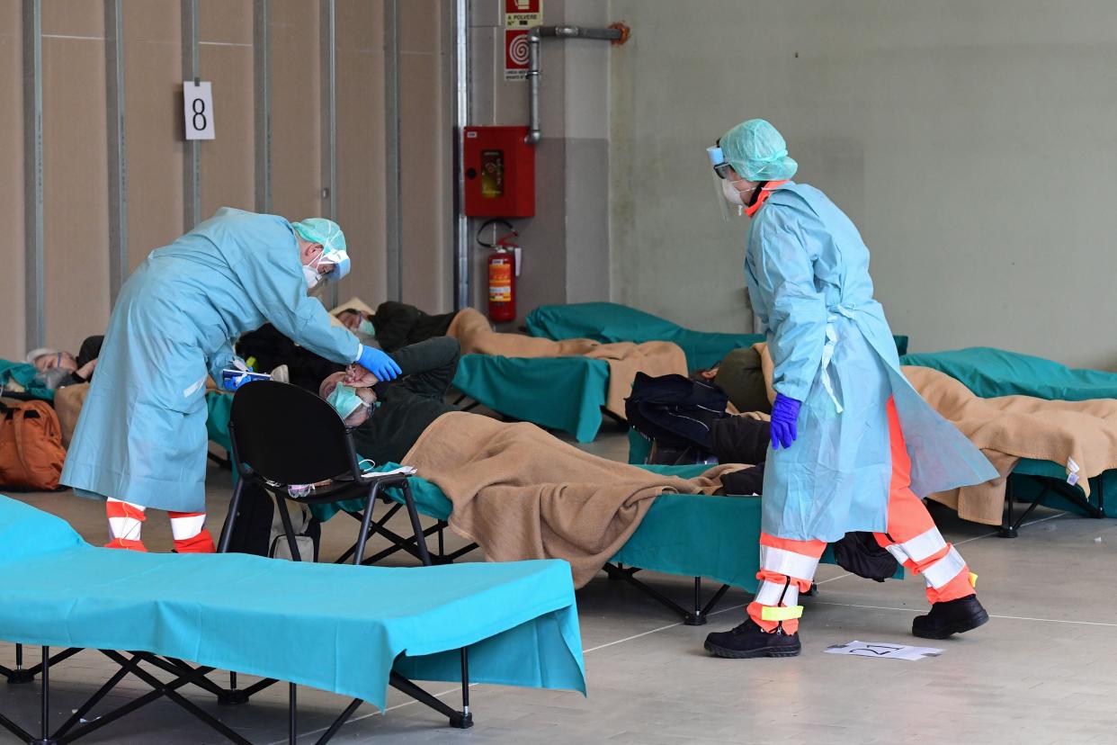 Hospital employees wearing a protection mask and gear tend to a patient at the Brescia hospital, Lombardy, on March 13, 2020.&nbsp; (Photo: MIGUEL MEDINA via Getty Images)