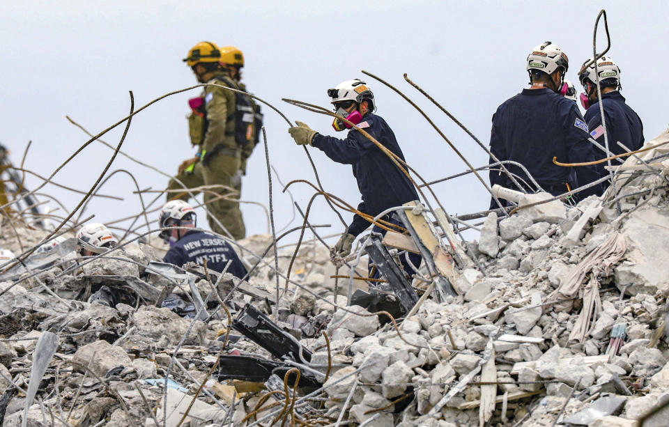 Varios socorristas revisan los escombros del edificio residencial Champlain Towers South, el miércoles 7 de julio de 2021, en Surfside, Florida. (Al Diaz/Miami Herald vía AP)