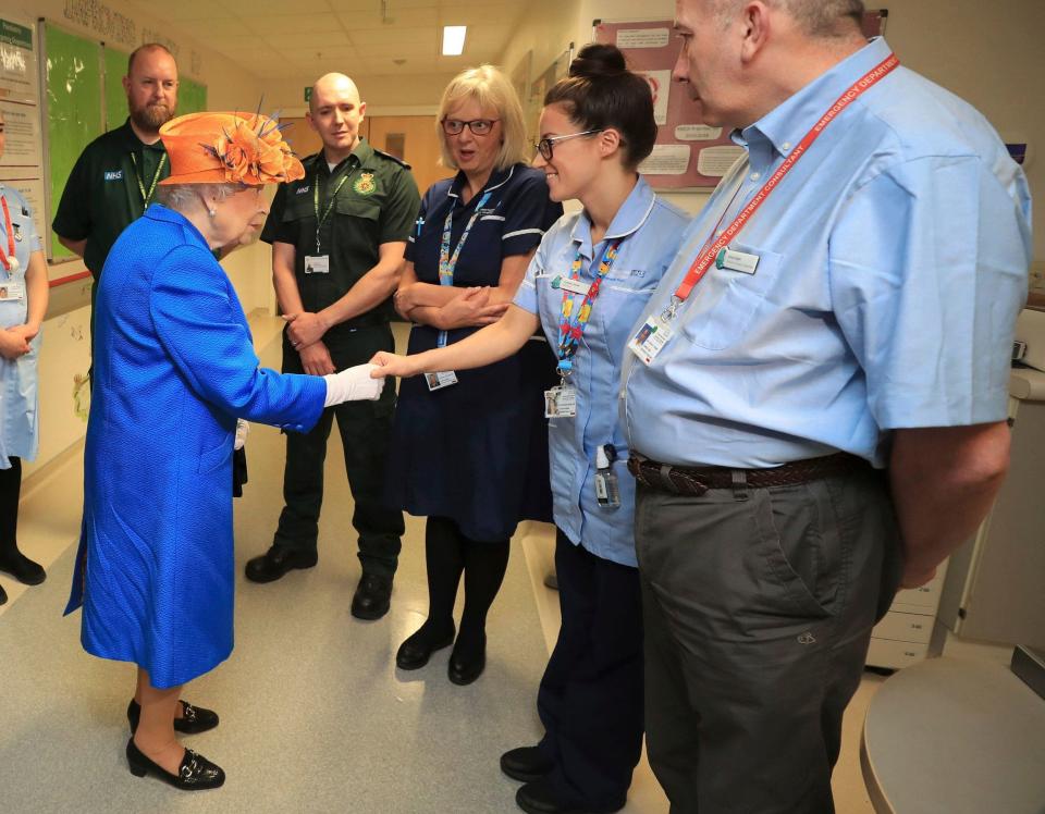 Queen Elizabeth II, centre, speaks with hospital personnel as she visits the Royal Manchester Children's Hospital - Credit: Peter Byrne/Pool via AP