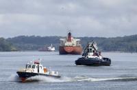 Cargo ships navigate Panama Canal waters in Gamboa, Panama, Wednesday, June 17, 2020. The Panama Canal began to feel the first adverse effects of the coronavirus pandemic on its business after registering a drop in its ship transits while applying rigorous measures to prevent further contagion among its workers. (AP Photo/Arnulfo Franco)