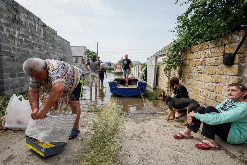 Local residents evacuate personal belongings and pets from a flooded area after the Nova Kakhovka dam breached, in Kherson