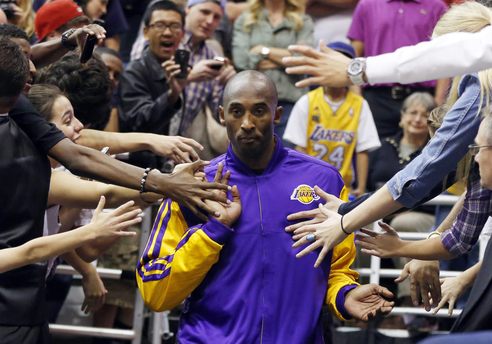 Los Angeles Lakers Kobe Bryant walks past fans before their NBA basketball game against the Utah Jazz in Salt Lake City