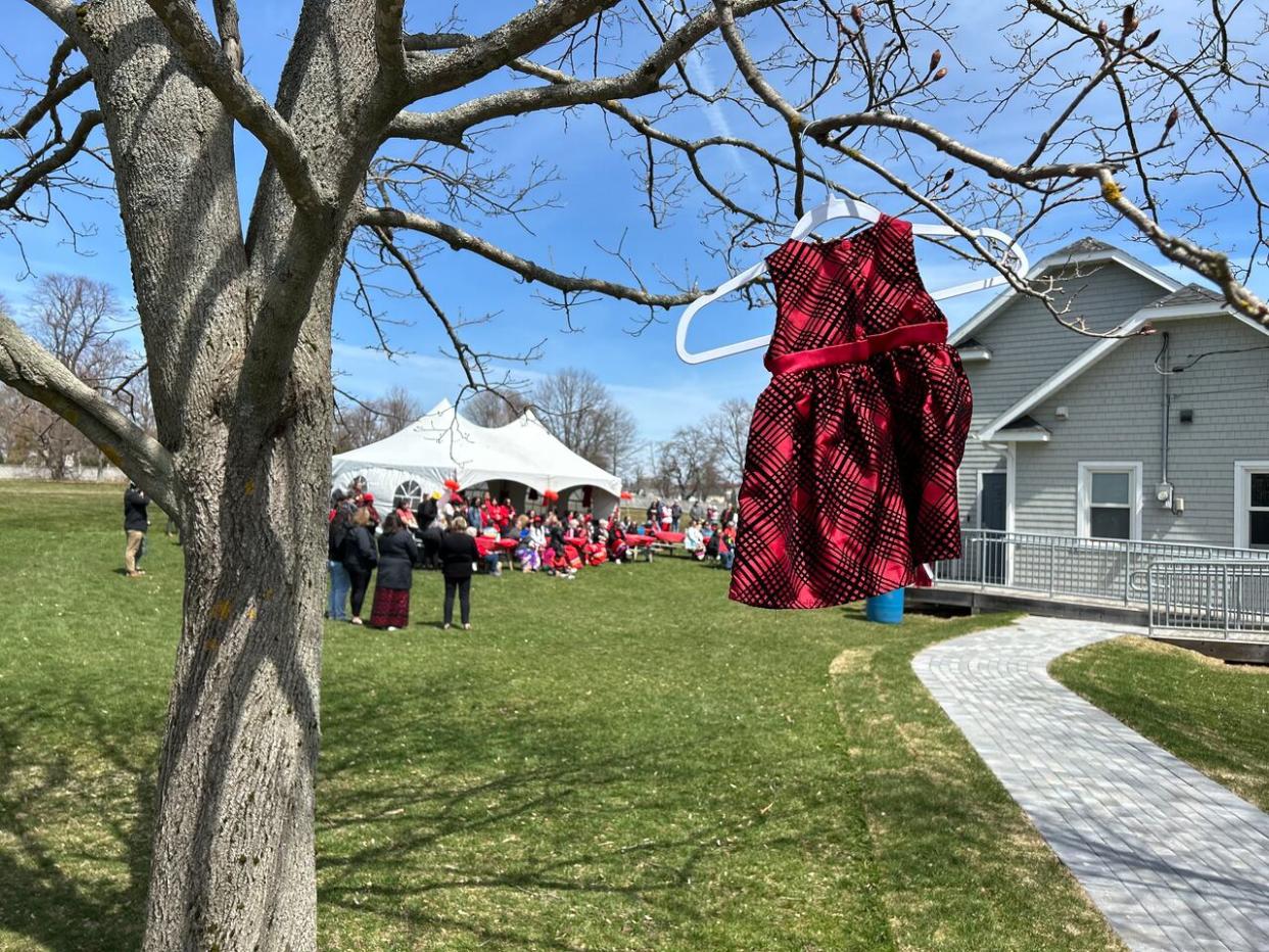 A small red dress hangs from a tree in Victoria Park on Saturday to honour missing Indigenous women, girls and two-spirited people. (Shane Ross/CBC - image credit)