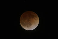 This photo shows the Earth's shadow cast over the surface of the moon as a total lunar eclipse over the Chabot Space and Science Center observatory in Oakland, Calif., Tuesday, April 15, 2014. (AP Photo/Jeff Chiu)