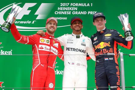 Formula One - F1 - Chinese Grand Prix - Shanghai, China - 09/04/17 - Winner Mercedes driver Lewis Hamilton of Britain celebrates on the podium with Ferrari driver Sebastian Vettel of Germany and Red Bull Racing driver Max Verstappen of the Netherlands after the Chinese Grand Prix at the Shanghai International Circuit. REUTERS/Aly Song