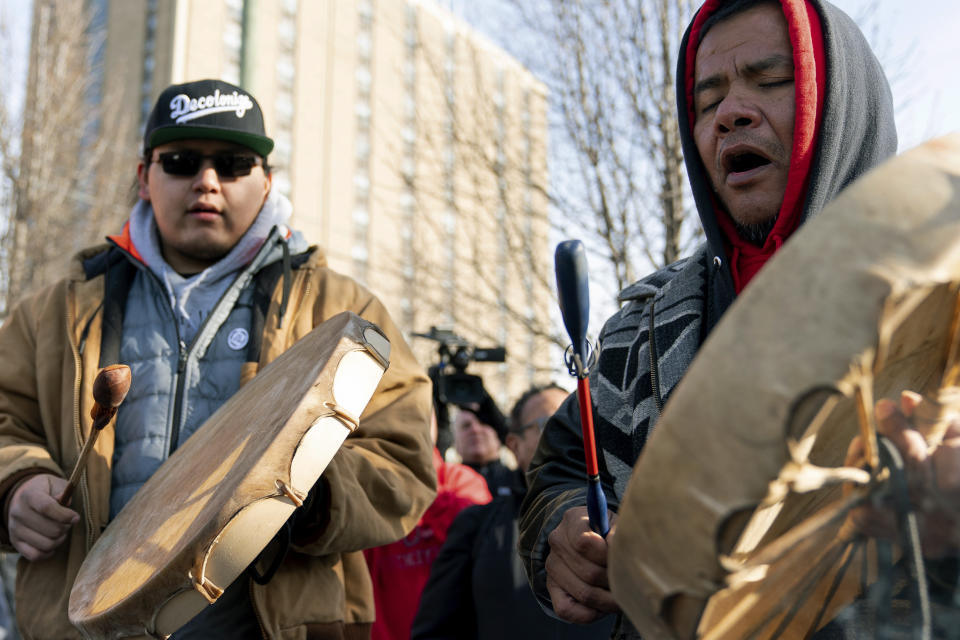 Sleepy Eye Lafromboise, derecha, y su hijo Eshtakaba, ambos de la nación Sioux, cantan durante una concentración de indígenas estadounidenses frente a la diócesis católica en Covington, Kentucky, martes 22 de enero de 2019. (AP Foto/Bryan Woolston)