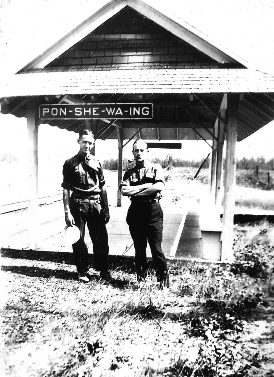 Two men pose for a photo at the original Ponshewaing flag stop, built by the Grand Rapids & Indiana Railroad in the late 1800s. Eventually demolished, the structure is the subject of a local reconstruction effort. A steering committee has been assembled to raise $50,000 to rebuild the flag stop on the old rail line — what is now the North Western State Trail.