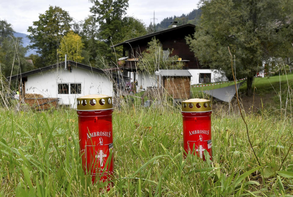 Candles are placed on a meadow behind a house in Kitzbuehl, Austria, Sunday, Oct. 6, 2019. Austrian police say a 25-year-old man's in custody after allegedly killing his ex-girlfriend, her family, and her new boyfriend in the Alpine resort town of Kitzbuehel. The 25-year-old turned himself to police in the town east of Innsbruck and admitted to the five slayings early Sunday morning, Austrian news agency APA reported. (AP Photo/Kerstin Joensson)