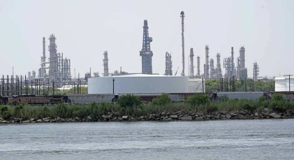 Storage tanks at a refinery along the waterway are shown Thursday, July 26, 2018, in Port Arthur, Texas. The oil industry wants the government to help protect some of its facilities on the Texas Gulf Coast against the effects of global warming. One proposal involves building a nearly 60-mile “spine” of flood barriers to shield refineries and chemical plants. Many Republicans argue that such projects should be a national priority. But others question whether taxpayers should have to protect refineries in a state where top politicians still dispute whether climate change is real. (AP Photo/David J. Phillip)