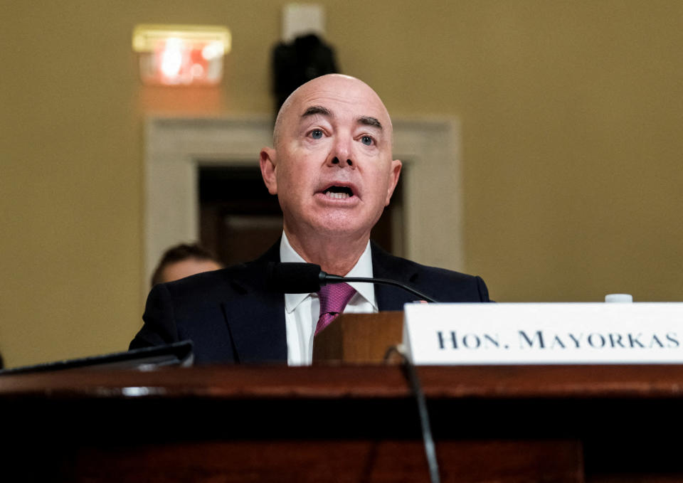 Alejandro Mayorkas testifies, with a nameplate in front of him saying: Hon. Mayorkas. 