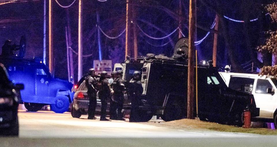 SWAT officers stand behind a Bearcat tactical vehicle during a standoff in the 2300 block of Blue Ridge Boulevard on Tuesday in Kansas City. The Kansas City Police Department said multiple officers were shot.