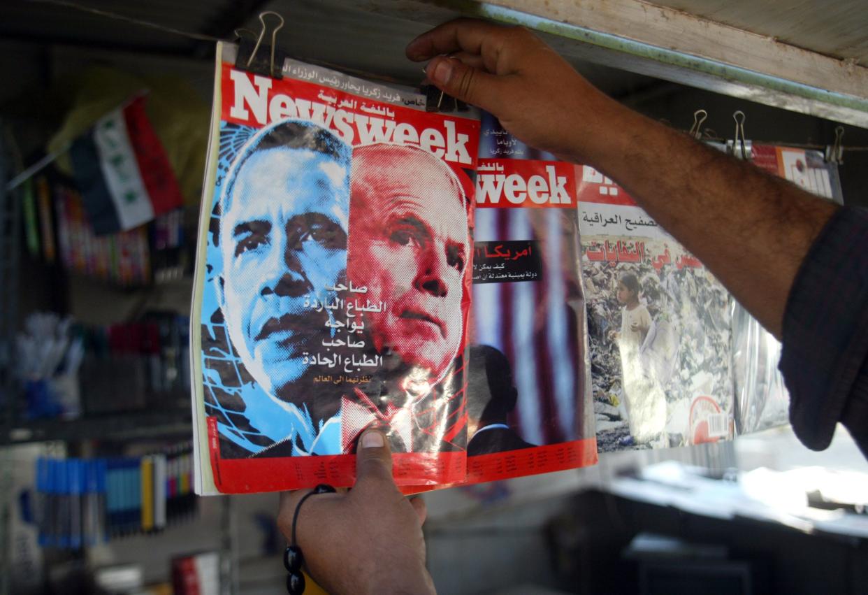 A kiosk owner attaches a magazine fronted with the images of the front-runners in the U.S. elections in central Baghdad, on Nov. 04, 2008.