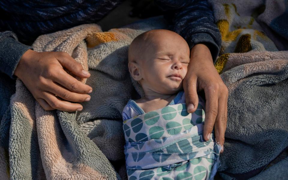 A woman cares for her newborn girl, Fatima, in Beirut's Martyrs' square after fleeing Israeli airstrikes