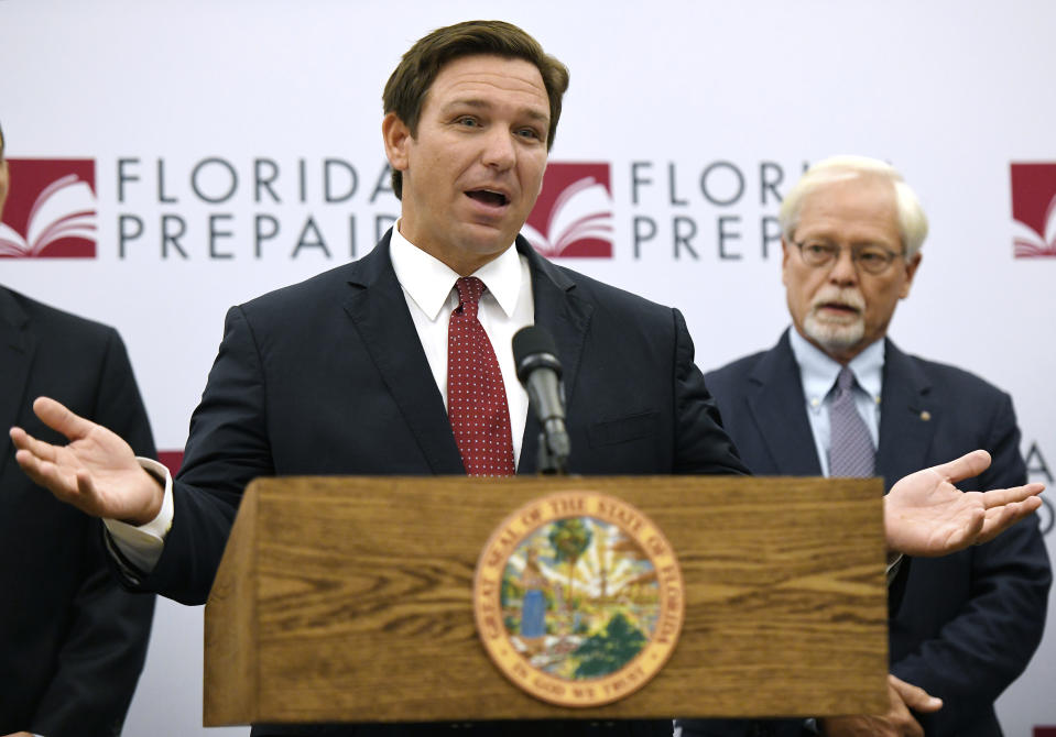 Florida Gov. Ron DeSantis, backed by Ambassador John Rood, announces that there would be refunds coming to families that have been paying into the Florida Prepaid tuition plan since 2008 and a reduction in the costs for new enrollments during a press conference in Jacksonville, Fla., Monday, Jan. 13, 2020. (Bob Self/The Florida Times-Union via AP)