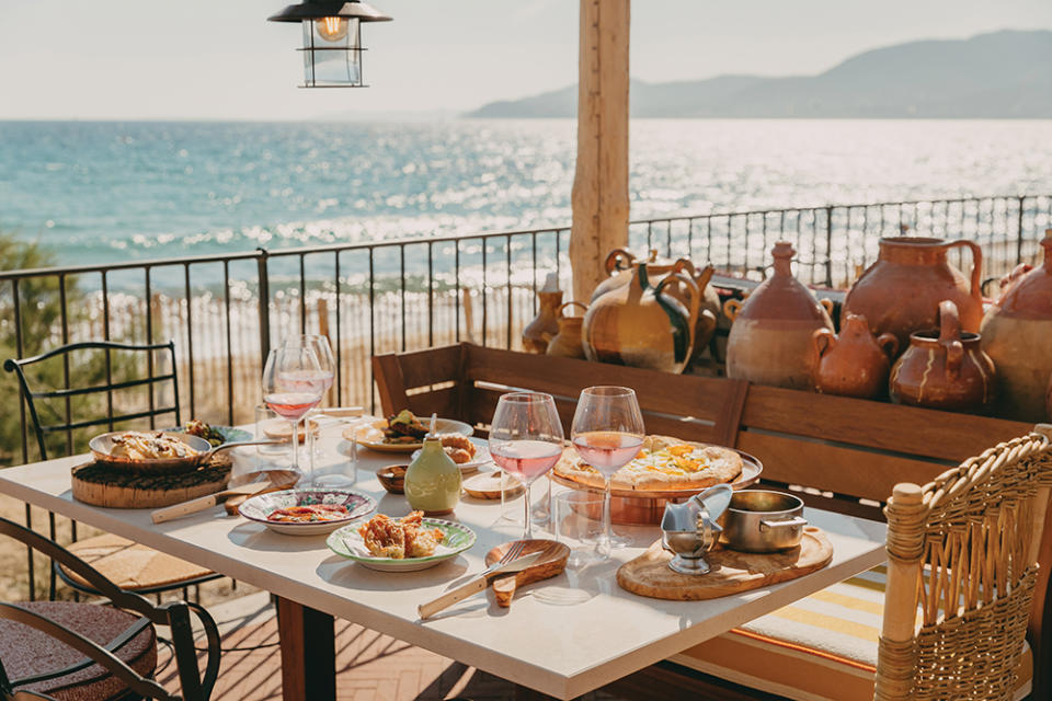 A meal of risotto croquette with meat and mozzarella is served with with
a pizza with ricotta, bufala mozzarella, zucchini, egg yolk, pesto and bottarga on the terrace
of the restaurant Brigantine.