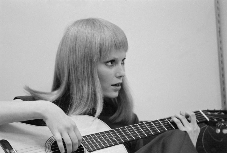 <p>Farrow plays around on the guitar, as she waits behind the scenes on the set of <em>John and Mary</em>, which was filmed in New York. </p>