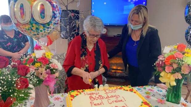 Crewe and Pleasantview Manor owner Rhonda Simms look over the cake at Crewe's 100th birthday party.