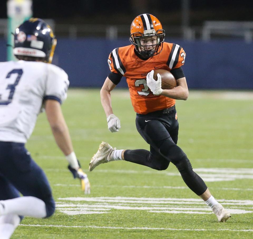 Jack Osborne of Versailles runs into the open field while keeping at eye on Ramon Lescano, 3, of Kirtland during their DV state championship game at Tom Benson Hall of Fame Stadium on Saturday, Dec. 4, 2021.