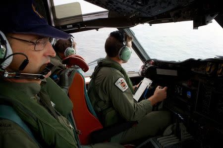 Co-Pilot, Flying Officer Marc Smith (R) and crewmen aboard a Royal Australian Air Force (RAAF) AP-3C Orion aircraft, search for the missing Malaysian Airlines Flight MH370 over the southern Indian Ocean in this March 24, 2014 file photo. REUTERS/Richard Wainwright/Pool/Files
