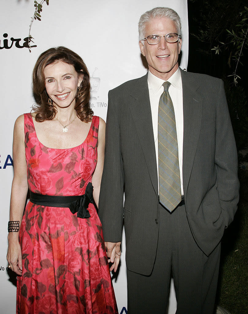 ted and mary are holding hands at a gala