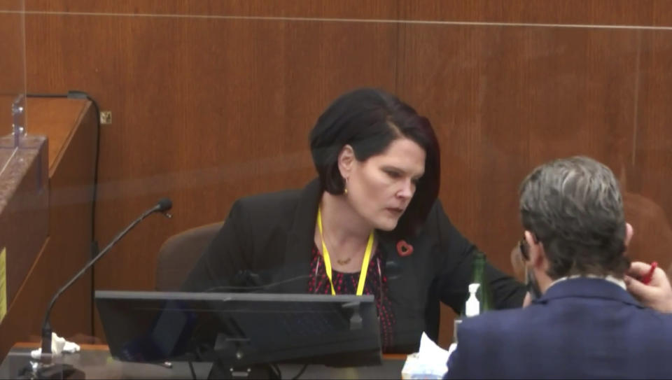 In this image taken from video, defense attorney Eric Nelson, shows witness Courteney Ross a transcript during questioning as Hennepin County Judge Peter Cahill presides Thursday, April 1, 2021, in the trial of former Minneapolis police Officer Derek Chauvin at the Hennepin County Courthouse in Minneapolis, Minn. Chauvin is charged in the May 25, 2020 death of George Floyd. (Court TV via AP, Pool)