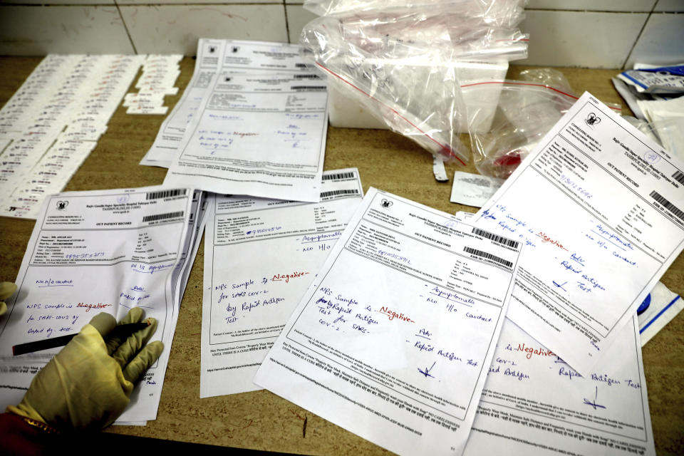 A health worker prepares the results of COVID-19 tests, most of which were found negative, at a hospital in New Delhi, India, Thursday, Feb. 11, 2021. When the coronavirus pandemic took hold in India, there were fears it would sink the fragile health system of the world’s second-most populous country. Infections climbed dramatically for months and at one point India looked like it might overtake the United States as the country with the highest case toll. But infections began to plummet in September, and experts aren’t sure why. (AP Photo/Manish Swarup)