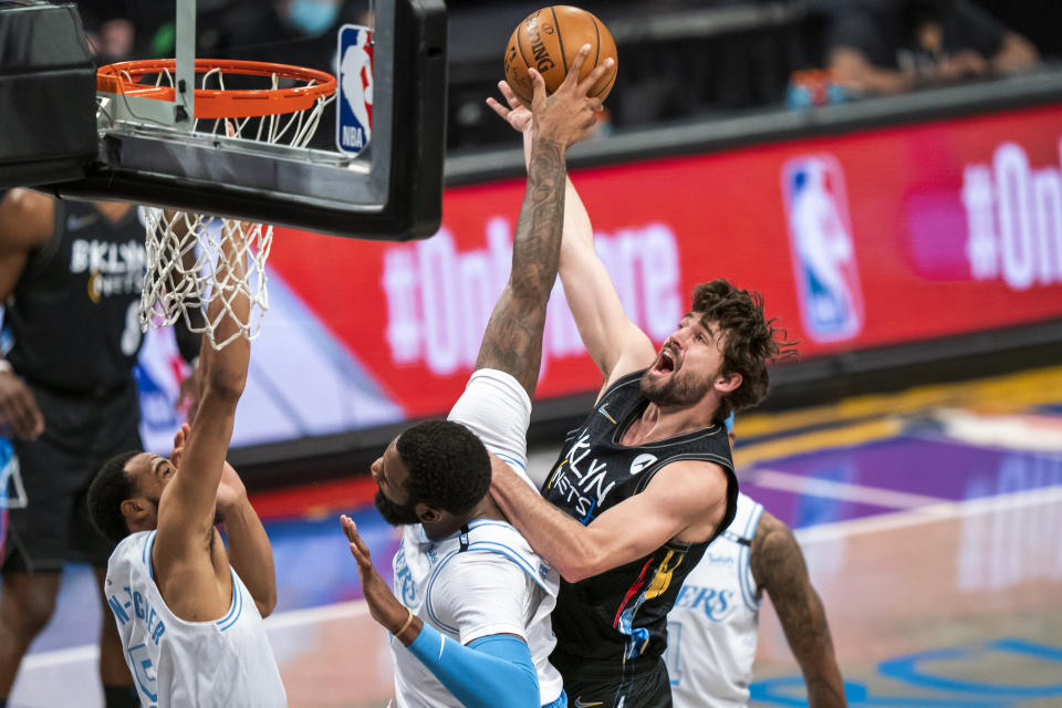 Los Angeles Lakers center Andre Drummond defends against Brooklyn Nets forward Joe Harris, top, during the first half of an NBA basketball game, Saturday, April 10, 2021, in New York (AP Photo/Corey Sipkin).