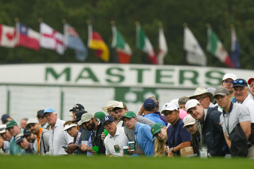 Patrons line the fairway on the first hole during the second round of the Masters golf tournament at Augusta National Golf Club on Friday, April 7, 2023, in Augusta, Ga. (AP Photo/Charlie Riedel)
