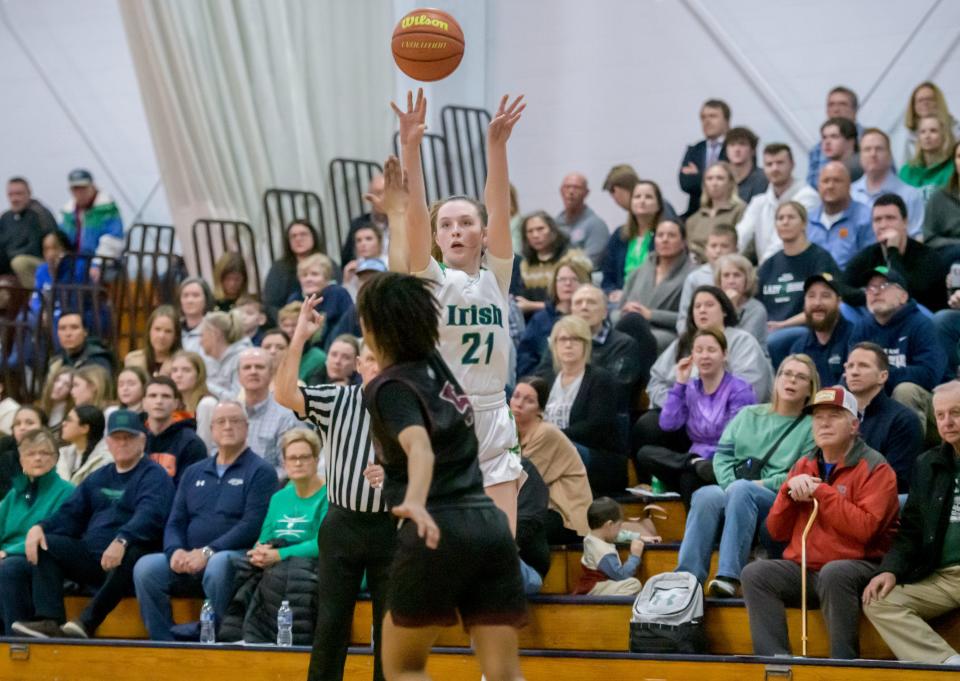 Peoria Notre Dame fans watch as Kaitlin Cassidy (21) puts up a three-pointer over Peoria High's Daniell Ruffin in the second half Thursday, Jan. 19, 2023 at PND High School. The Lions defeated the Irish 47-37.