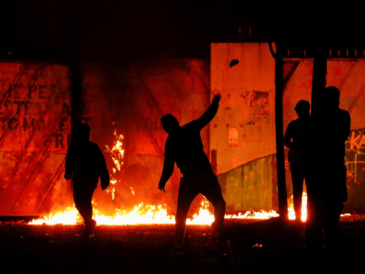 Rioters are seen at the ‘peace wall’ gate into Lanark Way as protests continued in Belfast on Wednesday (REUTERS)