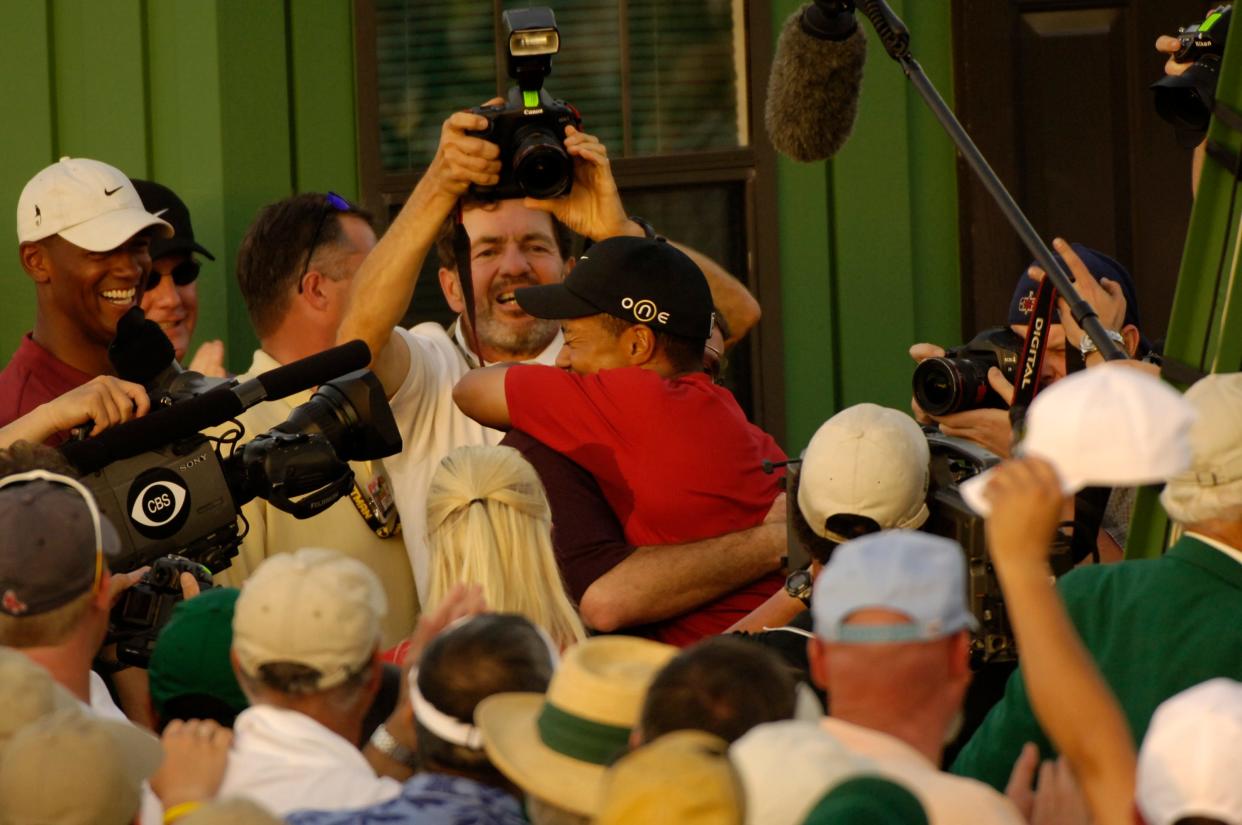 Tiger Woods celebrates his 2005 Masters win as golf photographer Steve Szurlej is there holding his camera overhead to capture the moment.