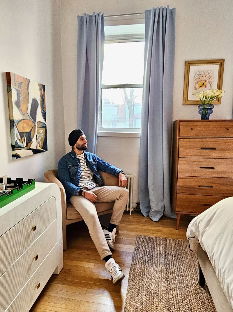 man sitting in chair in his bedroom